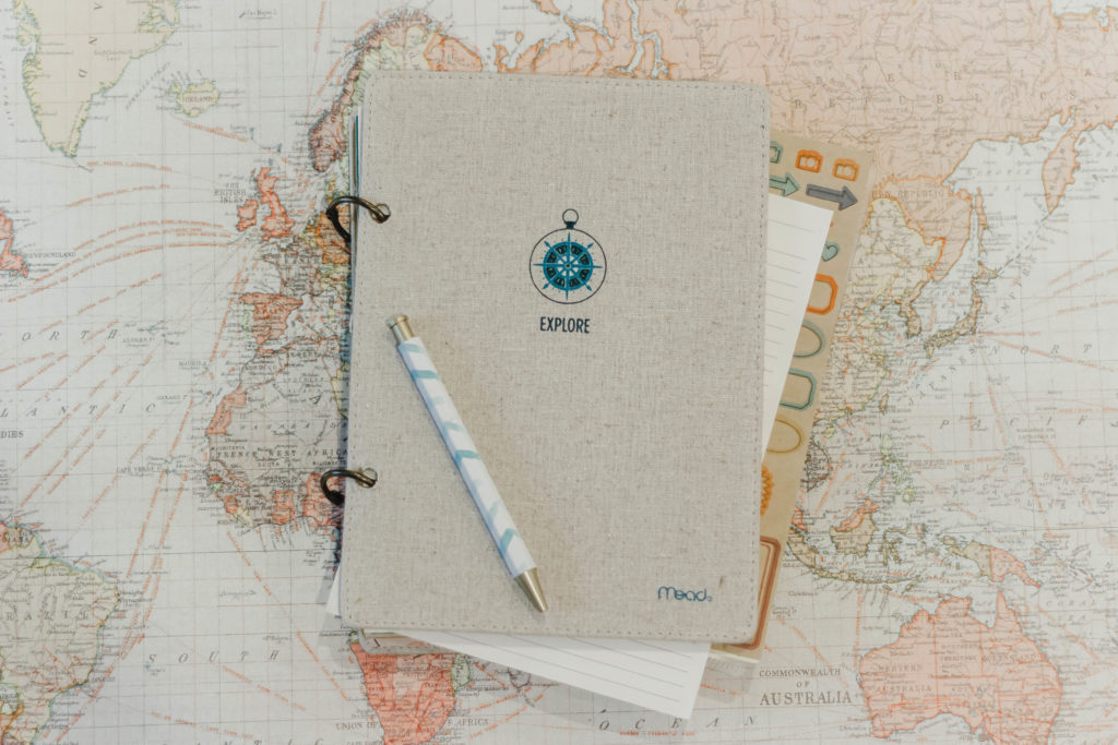 Travel journal and pen on map