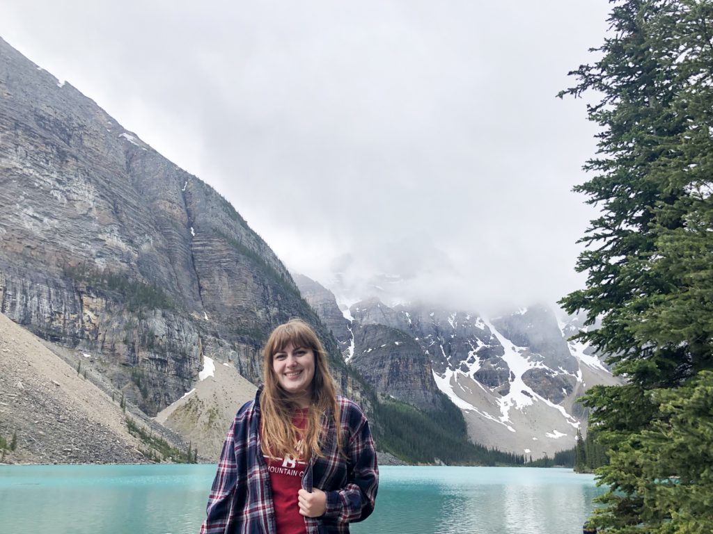 Girl in flannel in front of Moraine Lake and Mountains in Banff