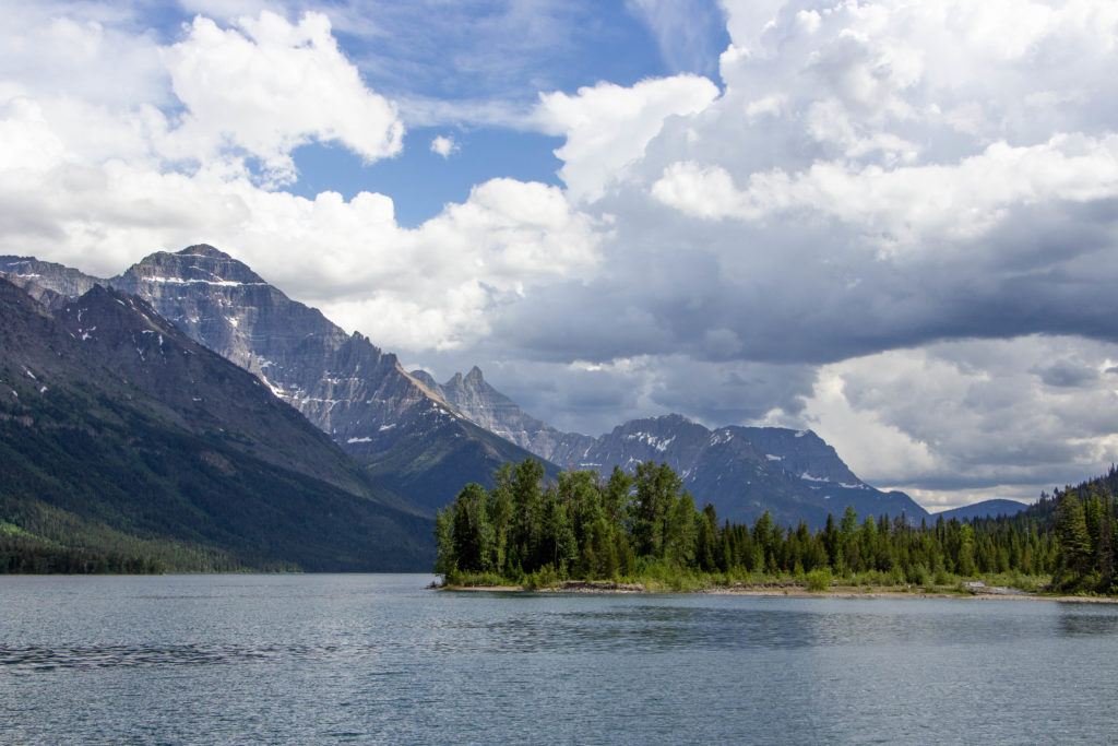 Waterton Lake and mountains on cloudy day with blue sky in Alberta Canada