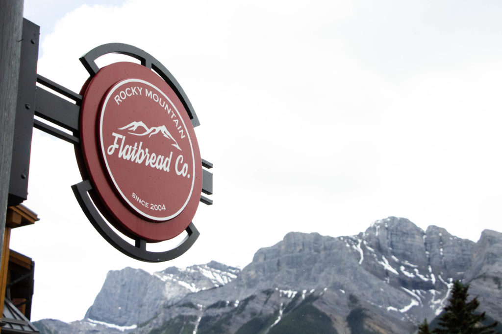 Rocky Mountain Flatbread Co. sign with mountains in background