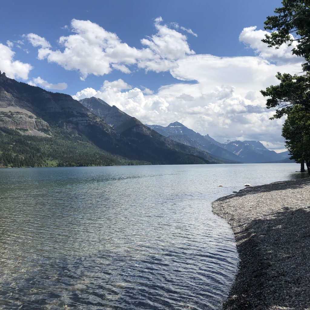 river and mountains at waterton alberta canada under blue sky