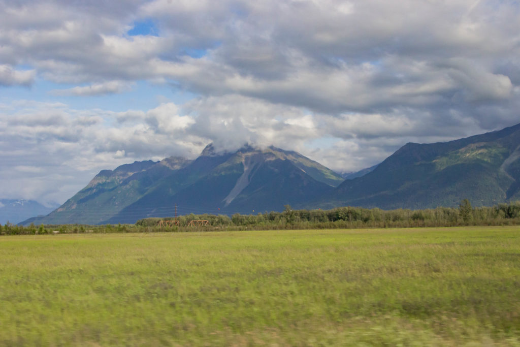 scenic Mountains, blue sky and clouds, green grass, landslide near anchorage alaska
