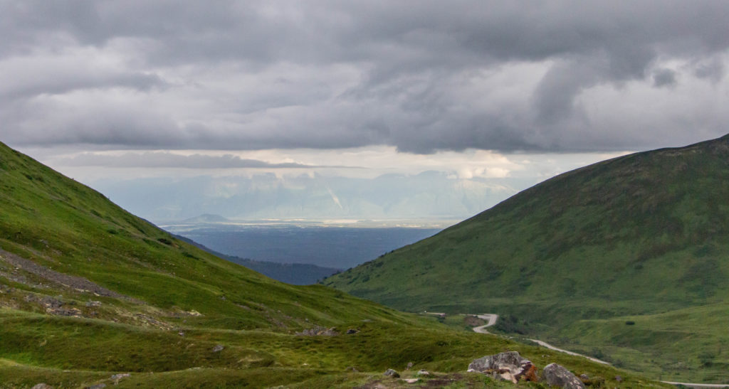 Blue sky and gray clouds over anchorage alaska view from green mountains and road of hatcher pass
