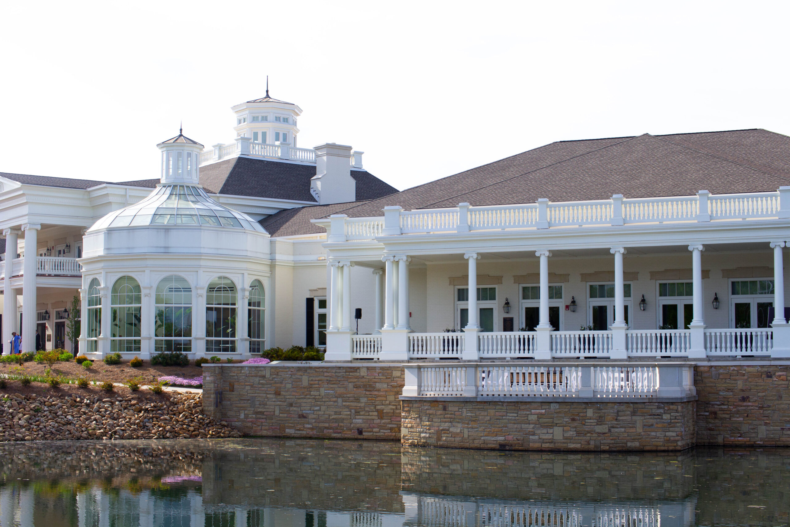 beautiful white building with many windows over water in huntsville botanical garden in alabama