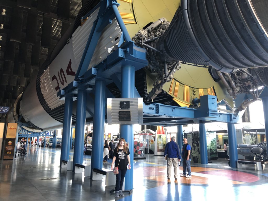 girl in front of indoor giant saturn 5 rocket at US space and rocket center in huntsville alabama