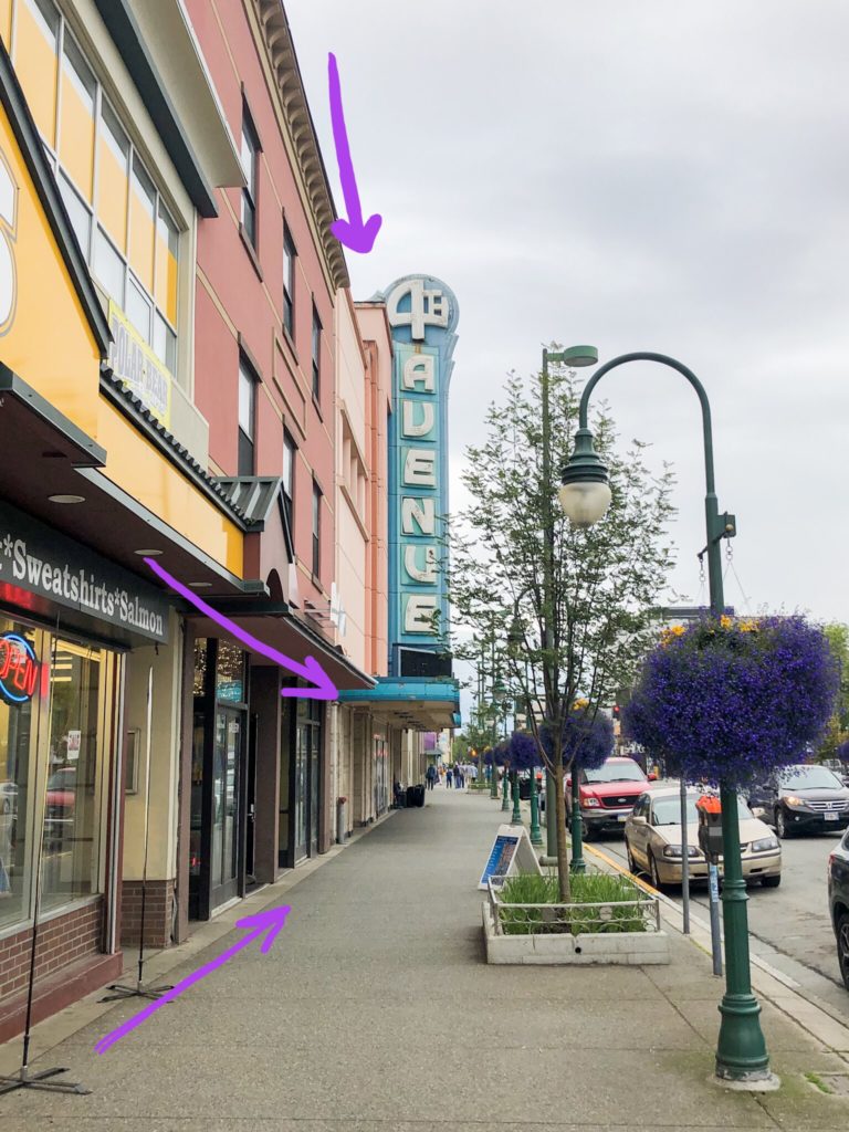 antique 4th avenue sign in downtown anchorage alaska demonstrating leading lines for photography with purple arrows and flowers