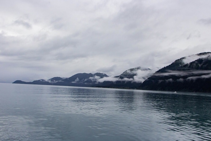 crooked horizon example of blue mountains, ocean, and clouds and fog in seward alaska