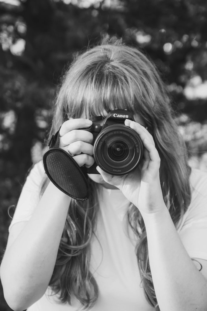 black and white girl taking photo with canon camera