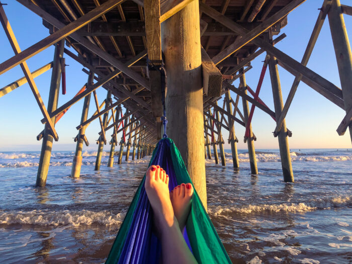 Gifts for Travelers - relaxing in an ENO hammock over the waves, under the pier at Folly Beach, South Carolina