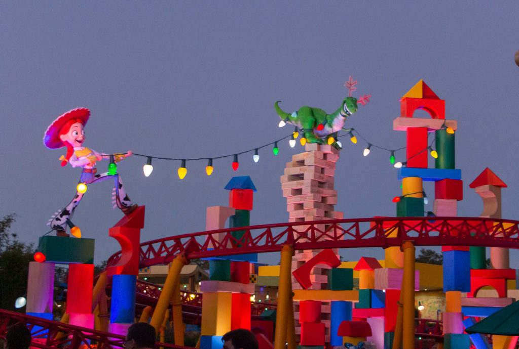 toy story land slinky dog dash with jessie and rex holding Christmas lights decorations Disney World at Christmas Time