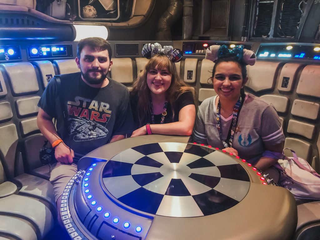 siblings boy with Star Wars shirt and 2 girls sitting at holo chess table inside millenium falcon at Star Wars galaxy's edge Disney World Hollywood Studios Orlando Florida