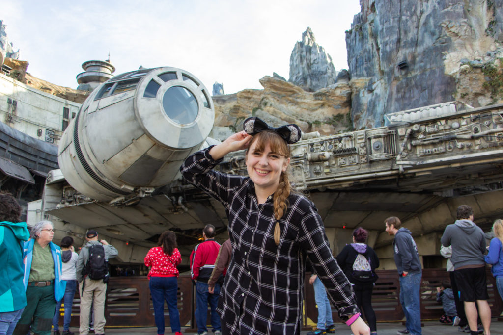girl with braid and black plaid shirt and mickey ears in front of millennium falcon Star Wars galaxy's edge Hollywood Studios Hollywood Studios Orlando Florida