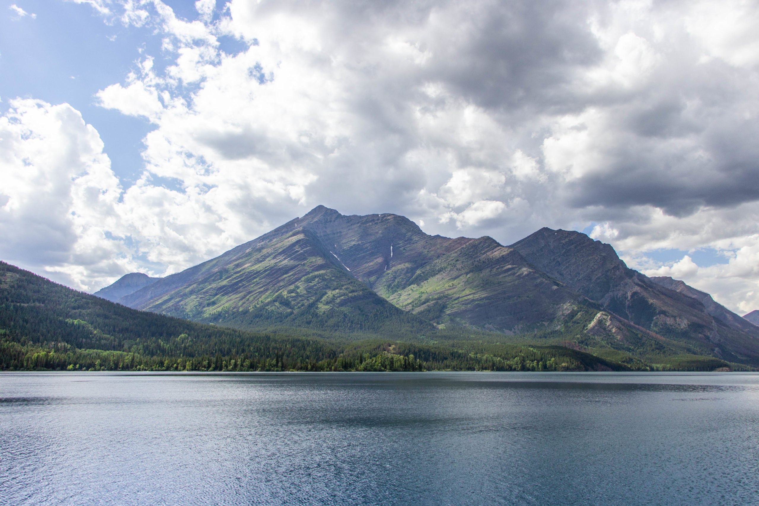mountain, blue sky with clouds, blue lake in Waterton lakes national park Alberta Canada