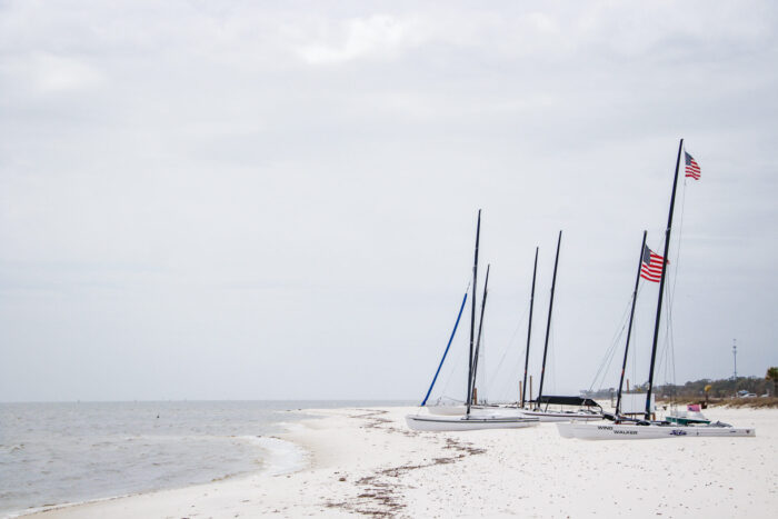Day Trip to Long Beach, Mississippi - sailboats in the sand on a cloudy day by the ocean