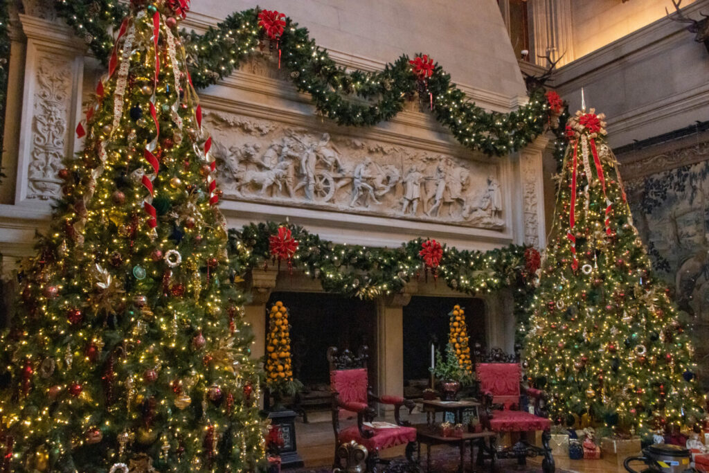 Why You Should Visit the Biltmore Estate at Christmas Time - The fireplace of the Banquet Hall decorated for Christmas with two trees