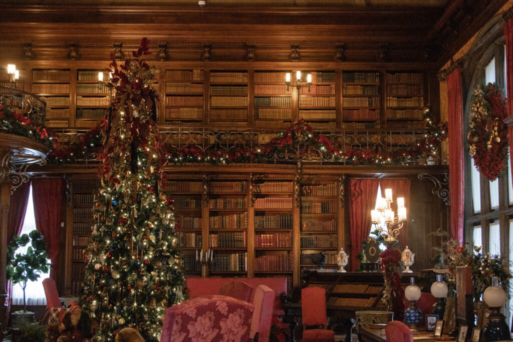 Why You Should Visit the Biltmore Estate at Christmas Time - the massive library decorated with Christmas trees