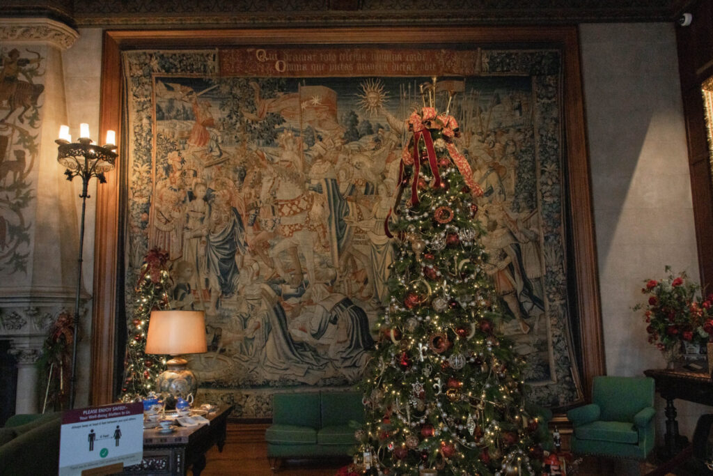 Why You Should Visit the Biltmore Estate at Christmas Time - large antique tapestry and Christmas tree inside the Biltmore house