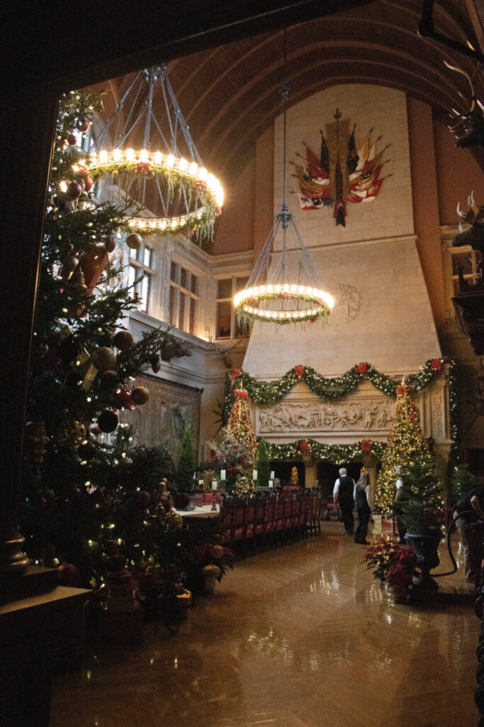 Why You Should Visit the Biltmore Estate at Christmas Time - Banquet Hall decorated for Christmas with large tree, fireplace, and chandeliers