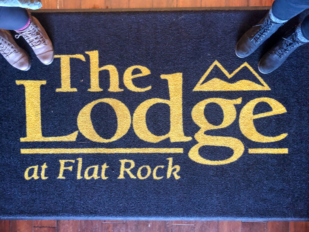 Things to Do on a Day Trip to Flat Rock, North Carolina - The Lodge at Flat Rock welcome mat with our hiking boots